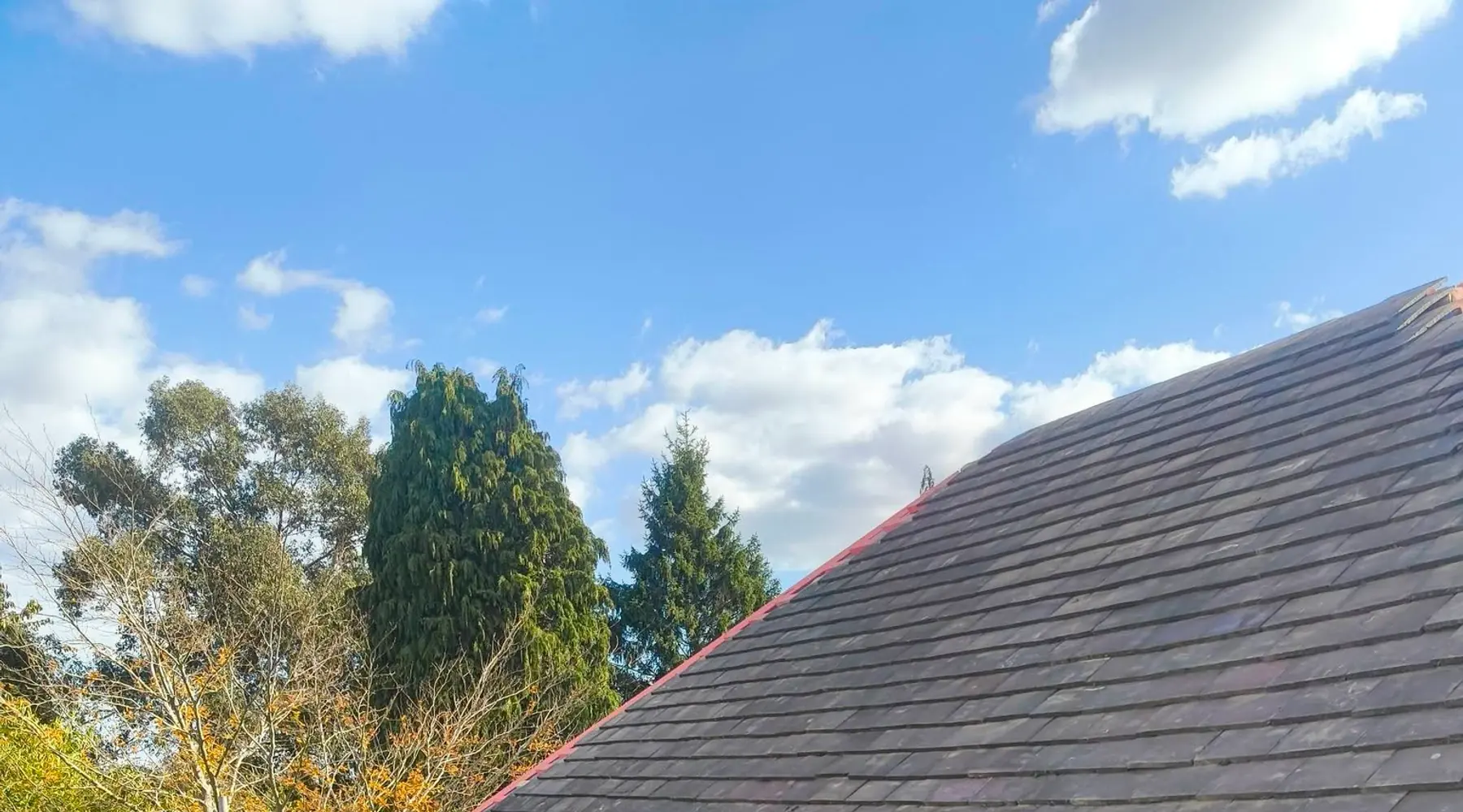 Newly finished tiled roof against a blue sky, Redditch