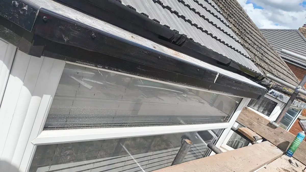 New black roofline and gutter above a conservatory